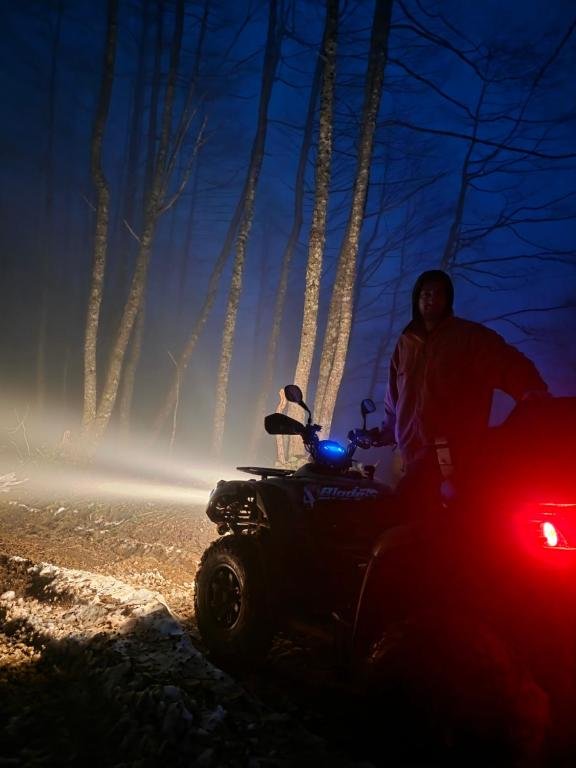 Nächtliche Quad-Fahrt mit Scheinwerfern auf einer Bergstraße